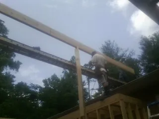 Carpenter setting a ridge beam over a new addition frame — Ice Dam Removal by Roofing Brothers in Woolford